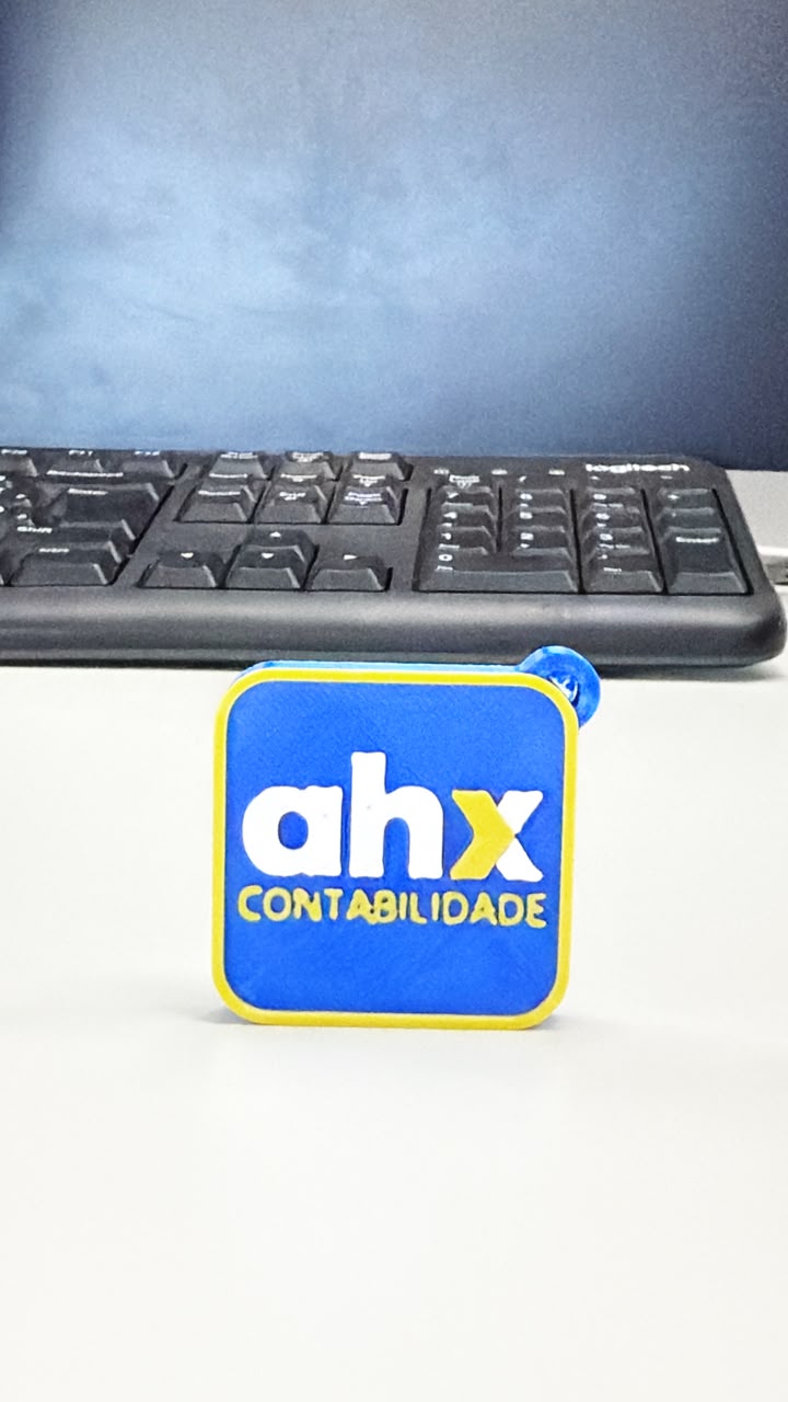 Chaveiro NFC azul e amarelo com a marca AHX Contabilidade em alto-relevo