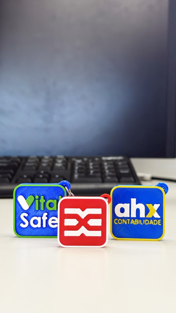 Três chaveiros NFC personalizados impressos em 3D com as marcas VitalSafe, Engetex e AHX Contabilidade
