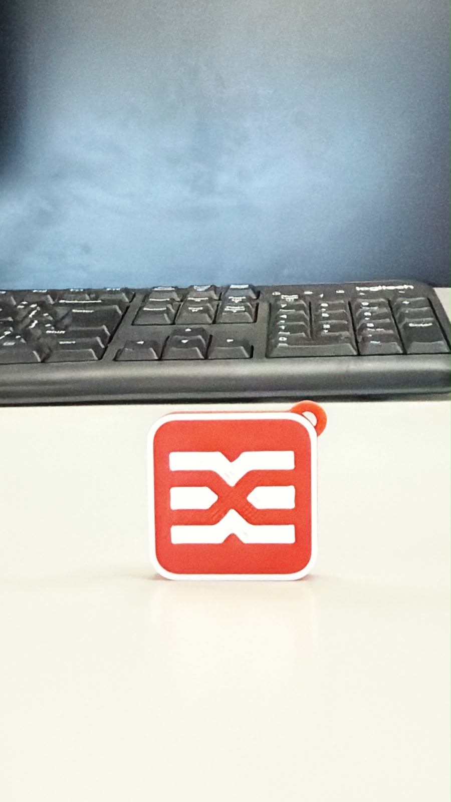 Chaveiro NFC vermelho e branco com o símbolo da Engetex em duas cores