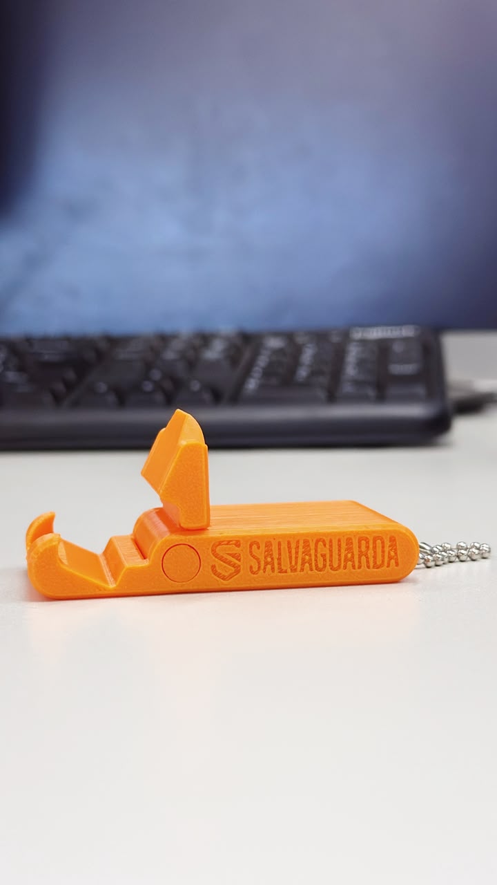 Suporte de celular laranja impresso em 3D com a marca Salvaguarda gravada